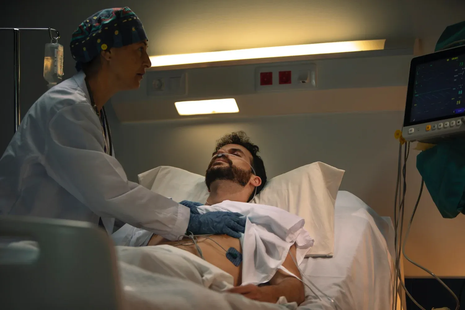 patient lying on a table in a cath lab, surrounded by medical equipment for a cardiac procedure