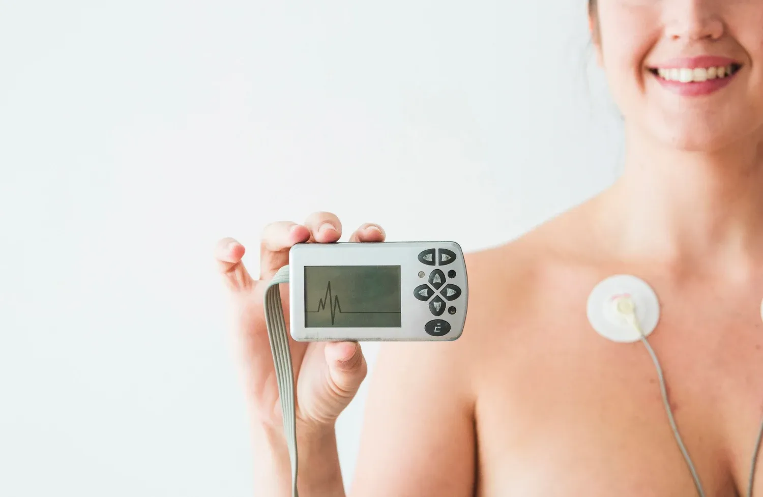 person wearing a holter monitor, a portable EKG device, with electrodes attached to their chest for continuous heart monitoring